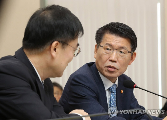 은성수 금융위원장(오른쪽)이 4일 오전 국회에서 열린 정무위 국정감사에서 관계자들과 대화를 나누고 있다. 연합뉴스